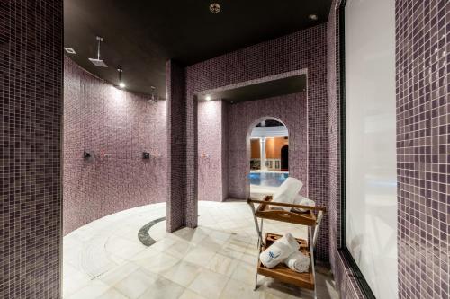 baño con pared de azulejos púrpura en Castilla Termal Solares, en Solares