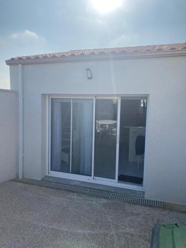 une grande fenêtre en verre dans un mur blanc dans l'établissement Studio mezzanine au calme, à Royan