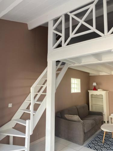 un salon avec un lit mezzanine et un canapé dans l'établissement Studio mezzanine au calme, à Royan