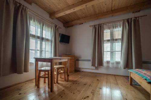 a room with a table and two windows and a bed at Biotour Camping & Restaurant in Ghimeş