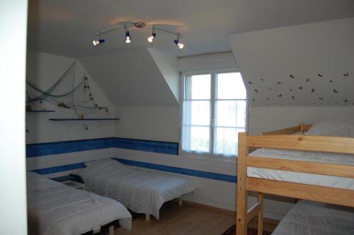 une chambre avec deux lits superposés et une fenêtre dans l'établissement La salicorne, à Barfleur