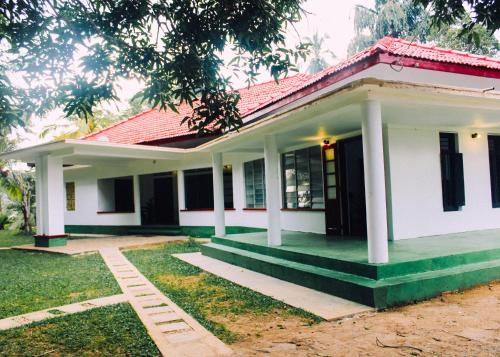 une petite maison blanche avec un toit rouge dans l'établissement DUTCH BUNGALOW galle, à Imaduwa