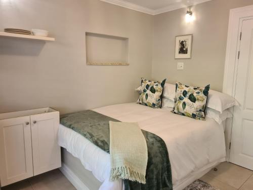 a bedroom with a white bed with pillows at Amberhall Guesthouse in Johannesburg