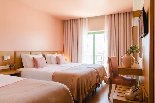 um quarto de hotel com duas camas e uma janela em Hotel Santo António de Fátima em Fátima