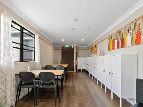 a classroom with tables and chairs and a row of lockers at Azzurro Boutique Hotel - Surry Hills in Sydney