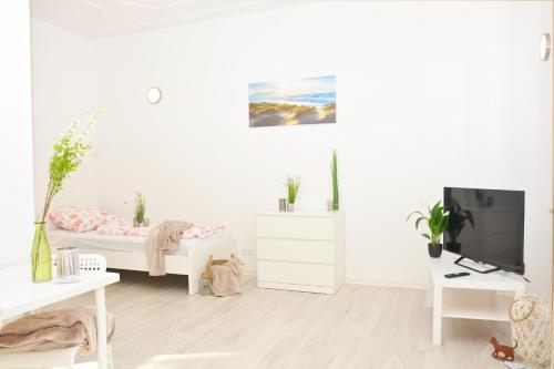 um quarto branco com uma cama e uma televisão em CO03-HI Apartment in Coburg em Coburgo