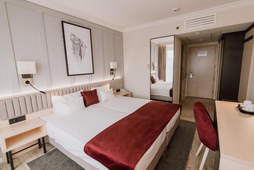 a hotel room with a large bed and a desk at Ensana Sovata in Sovata