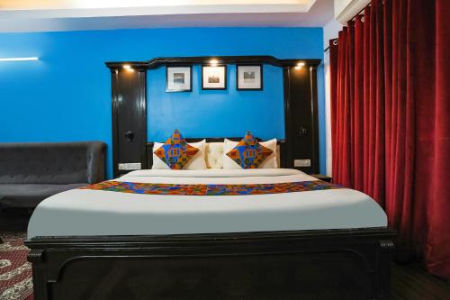 a bedroom with a large bed with a blue wall at FabHotel Sentinel Suites in New Delhi