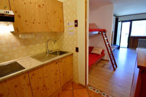a kitchen with a sink and a bunk bed at Nardis Studio 15 in Madonna di Campiglio