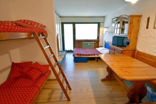 a room with a bunk bed and a table at Nardis Studio 15 in Madonna di Campiglio