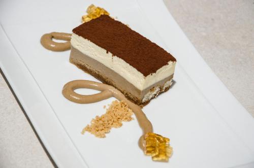 a piece of cake sitting on a white plate at Hotel Anfora Ibiza in Es Cana