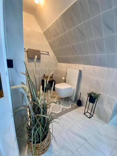 a bathroom with a toilet and some plants in it at Landhaus Lotten in Winsen Luhe
