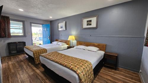 um quarto de hotel com duas camas e uma lareira em Travelers Inn em Flagstaff
