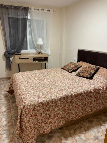 sypialnia z łóżkiem, biurkiem i oknem w obiekcie Уютная квартира в Calpe w mieście Calpe