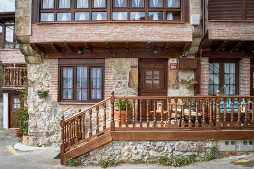 dom z drewnianą werandą i balkonem w obiekcie CASA GERRA COMILLAS w mieście Comillas