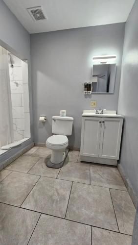 a bathroom with a toilet and a sink and a mirror at Travelers Inn in Flagstaff