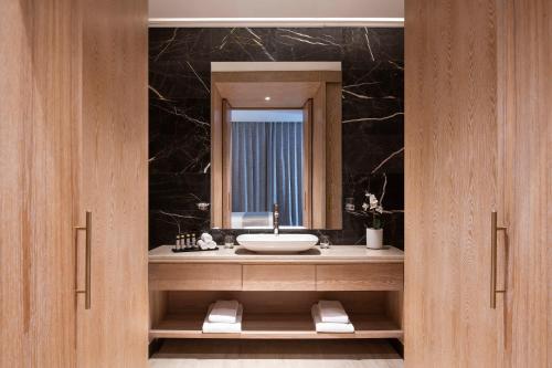 a bathroom with a sink and a mirror at The Bentley Luxury Hotel & Suites in Doha
