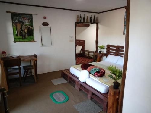 a bedroom with a bed and a table and a mirror at 20/20 wood cabana in Nuwara Eliya
