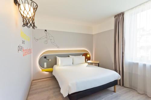 a hotel room with a bed and a window at IBIS Styles Kaunas Centre in Kaunas