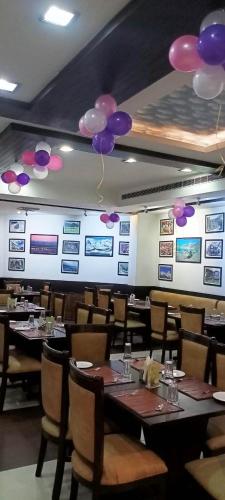 a dining room with tables and purple balloons on the wall at Mg Regency in Baddi