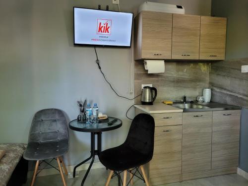 a kitchen with a table and two chairs and a tv on the wall at Sebar in Gorzyce