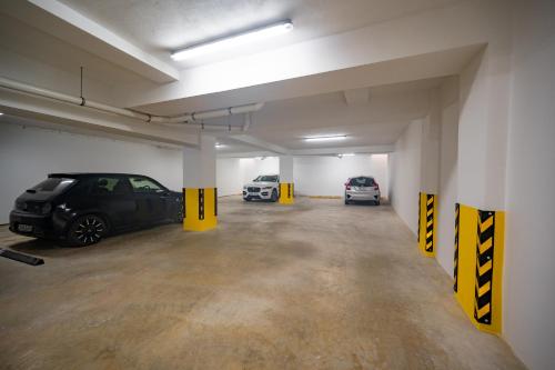 a parking garage with two cars parked in it at The Address Seafront Suites with Hot Tub in Pieta