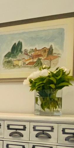 a vase with flowers sitting on top of a cabinet at Sul VenTo del Po in Melara