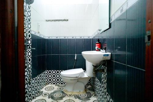a bathroom with a sink and a toilet and a mirror at RedDoorz Syariah near Unila in Bandar Lampung