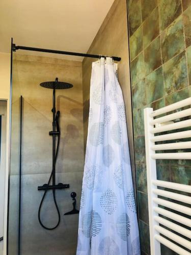 La salle de bains est pourvue d'une douche avec un rideau de douche blanc. dans l'établissement Villa avec piscine à 80 m de la plage, à Bretignolles-sur-Mer