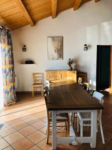 une salle à manger avec une table et des chaises en bois dans l'établissement Villa avec piscine à 80 m de la plage, à Bretignolles-sur-Mer