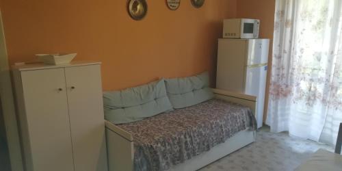 - une chambre avec un lit et un réfrigérateur blanc dans l'établissement Appartamento La Sorgente - Residenza Adalgisa, à Finale Ligure