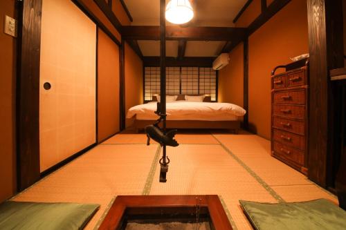 a room with a bedroom with a bed and a sink at Iroriyado Hidaya in Takayama
