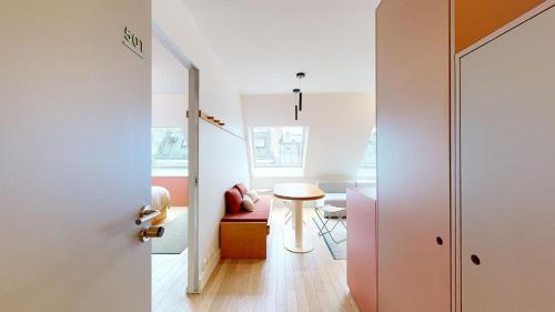 Cette petite chambre comprend une table et une chaise. dans l'établissement JOIVY Premium flats in the heart of the 9th arr, near Moulin Rouge, à Paris