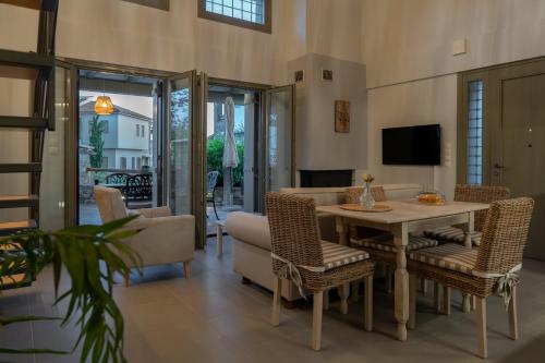 a living room with a table and chairs at Villa Jasmine in Platanidia