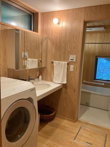ein Badezimmer mit einer Waschmaschine und einem Waschbecken in der Unterkunft Casa KitsuneAna The Satoyama experience in a Japanese-style modernized 100-year-old farmhouse in Akaiwa