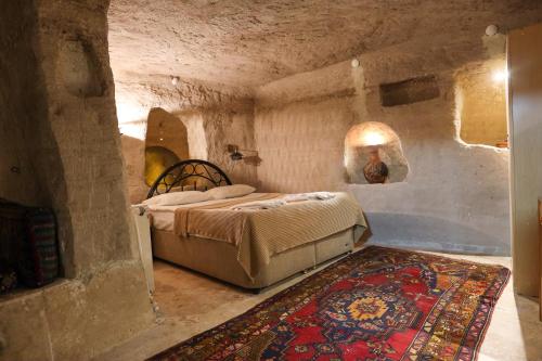 a bedroom with a bed in a stone room at Peri Cave Hotel in Goreme