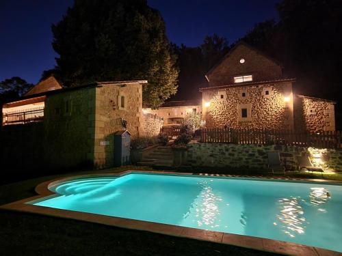 a swimming pool in front of a building at night at Le Clos de la Canéda in Sarlat-la-Canéda