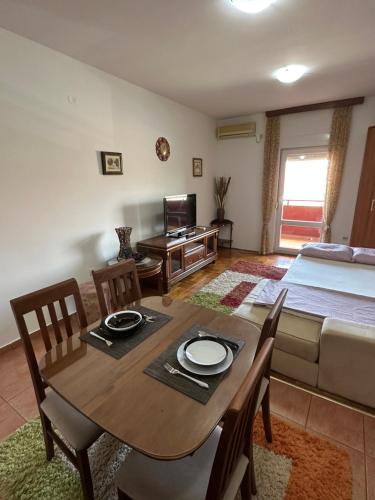 een woonkamer met een eettafel en een bed bij Bella Apartman in Podgorica