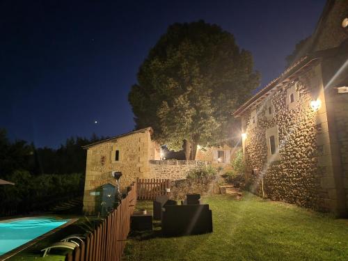 a stone house with a fence and a yard at night at Le Clos de la Canéda in Sarlat-la-Canéda