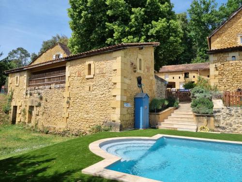 a house with a swimming pool in front of a building at Le Clos de la Canéda in Sarlat-la-Canéda