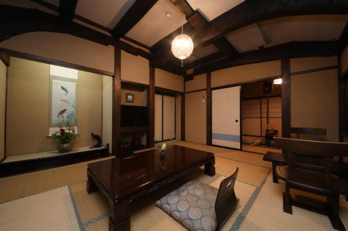 a living room with a wooden table and a couch at Iroriyado Hidaya in Takayama