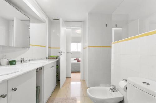 a white bathroom with two sinks and a toilet at Casa El Bosque, Playa Flamenca, Orihuela Costa in Playa Flamenca