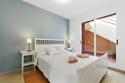 a bedroom with a white bed with two towels on it at Casa El Bosque, Playa Flamenca, Orihuela Costa in Playa Flamenca