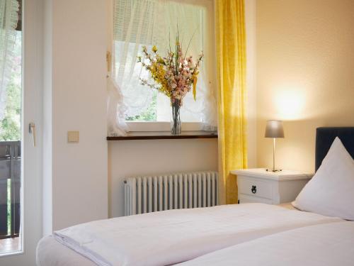 ゼーバハにあるSeebach-Hotelのベッドルーム1室(ベッド1台付)、窓に花瓶1本が備わります。