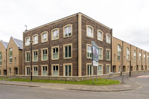 a large brick building on the side of a street at Mhuilinn Apartment in Stirling