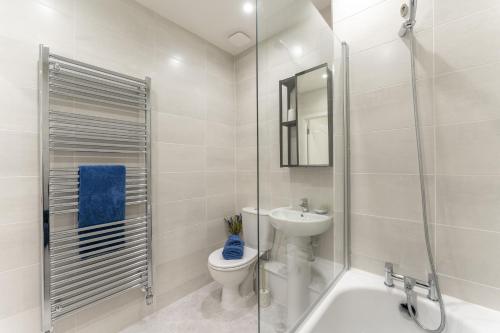 y baño con aseo, lavabo y ducha. en Mhuilinn Apartment en Stirling