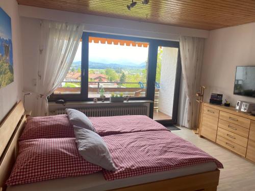 ein Schlafzimmer mit einem Bett und einem großen Fenster in der Unterkunft Ferienwohnung Moritz in Oy-Mittelberg