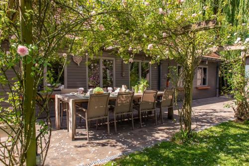a dining table and chairs in a garden at B&B Het Brembos in Wingene