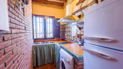 - une cuisine avec un mur en briques et un évier dans l'établissement El Secano de Paco Órgiva by Ruralidays, à Órgiva