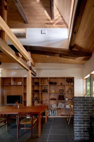 a dining room with wooden ceilings and a table at Casa KitsuneAna The Satoyama experience in a Japanese-style modernized 100-year-old farmhouse in Akaiwa